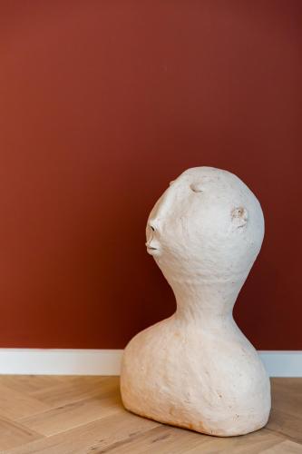 a vase sitting on a wooden floor in front of a wall at HARAS DE BARRY in Sainghin-en-Mélantois