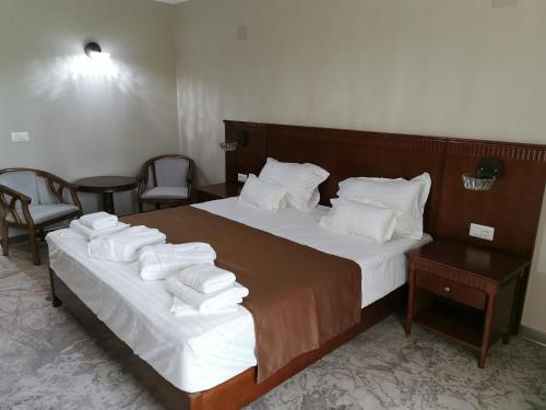 a hotel room with a bed with towels on it at Pensiunea JOJO Imperial Resort&Spa in Băile Herculane