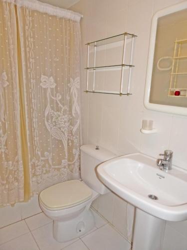 a white bathroom with a toilet and a sink at SALINAS CENTRO - PLAYA DE GANDIA in Playa de Gandia