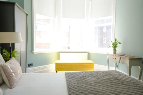 a bedroom with a bed and a chair and a window at Seaview Mansion Apartment - Central Hove with PARKING in Brighton & Hove