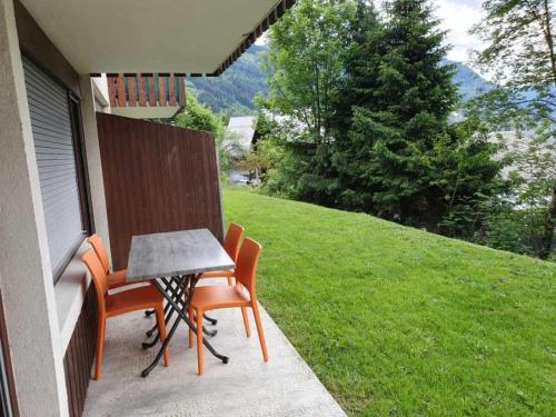 une terrasse avec une table et des chaises dans une maison dans l'établissement Appartement 6 Personnes les daims 2 chambres, à Châtel