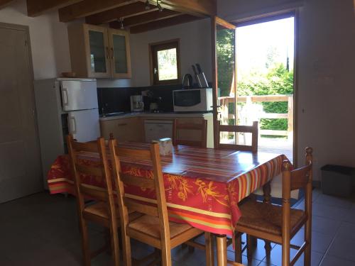 une cuisine avec une table en bois avec des chaises et un réfrigérateur dans l'établissement Camping La Prairie, à Mars