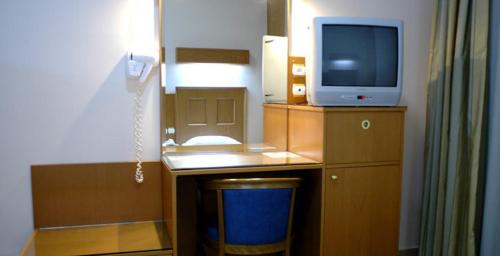 a room with a desk with a tv on a desk at Katerina Hotel in Kozani