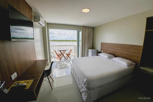 a hotel room with a bed and a balcony at Hotel Orla do Rio Branco in Boa Vista