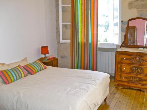 a bedroom with a bed and a dresser and a window at Maison Mauro in Prats-de-Mollo-la-Preste