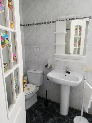 a bathroom with a sink and a toilet and a mirror at Sun and Sea House 3 Rooms & Wifi in Arinaga