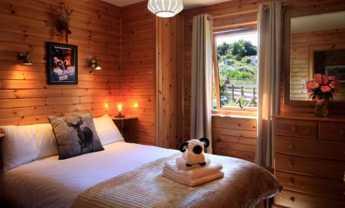 un dormitorio con una cama con un animal de peluche en Reuben's Highland Retreat - Arisaig, en Arisaig