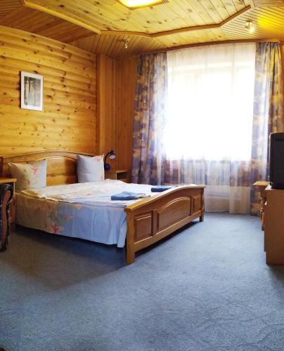 a bedroom with a bed in a wooden room at Guest House Shafran in Yaremche