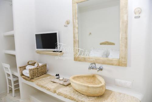 uma casa de banho com um lavatório e um espelho em Art Village em Pánormos