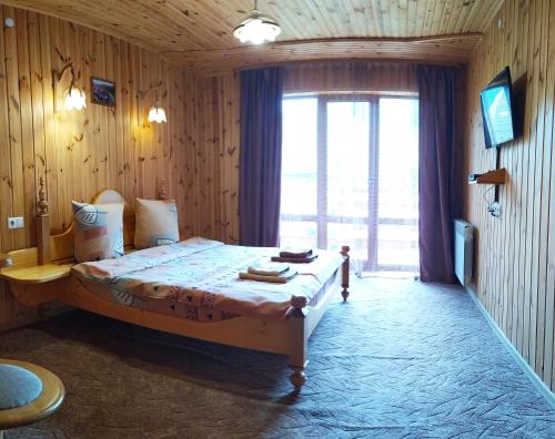 ein Schlafzimmer mit einem Bett und einem großen Fenster in der Unterkunft Guest House Shafran in Jaremtsche
