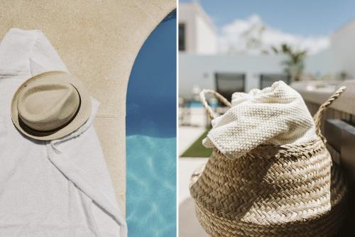 a straw bag and a hat next to a pool at Villa Flamboyan in Yaiza