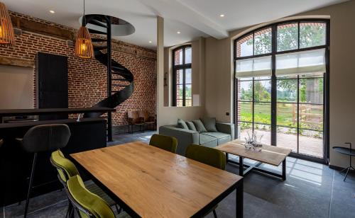 sala de estar con mesa de comedor y pared de ladrillo en HARAS DE BARRY en Sainghin-en-Mélantois