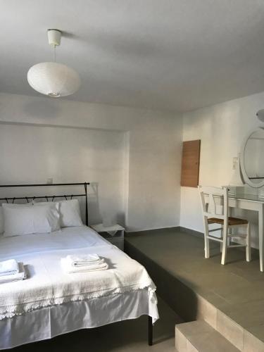 Vegera Apartment 'Ostria', Stavros Donoussa في دونوسا: غرفة نوم بسرير وطاولة وكرسي