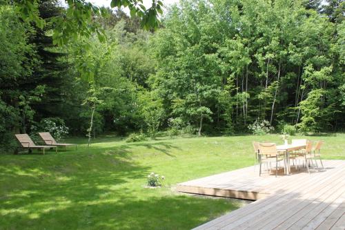 a wooden deck with a table and chairs in a yard at Ferienhaus Chalet Goldberg in Bad Harzburg