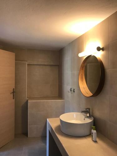 Vegera Apartment 'Ostria', Stavros Donoussa في دونوسا: حمام مع حوض ومرآة وحوض استحمام