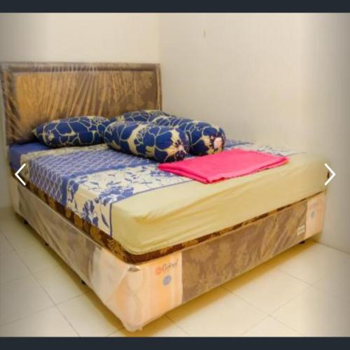 Una cama en una habitación con dos cajas. en Penginapan Sriwijaya, en Tanjung Pandan