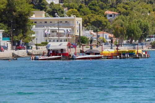 a group of boats are docked on the water at Euphoria House in Poros