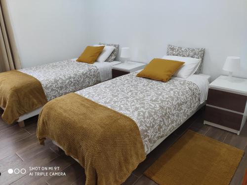 Varandas do Basalto في Queimada: سريرين في غرفة صغيرة بسريرين