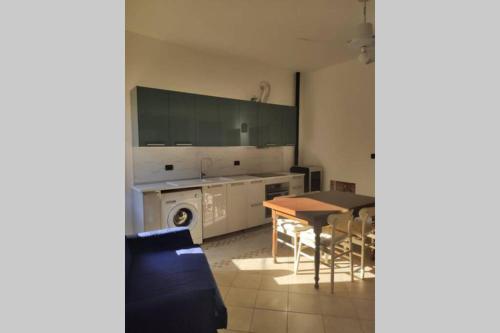 a living room with a table and a kitchen at La Casa di Principino in Giglio Porto