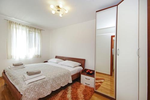 1 dormitorio con cama y espejo grande en Delux Apartman Jukic, en Makarska