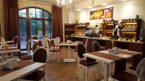 a restaurant with tables and chairs in a room at Dworek Nad Stawem & Łaźnia Piwna in Ostrów Mazowiecka