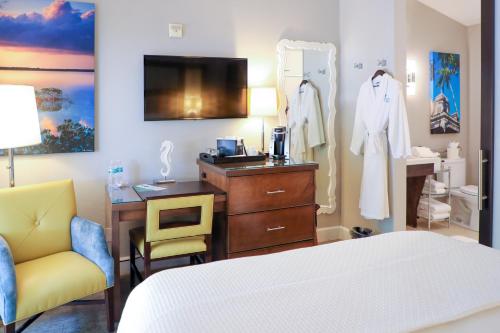 a hotel room with a dresser and a bed at Almond Tree Inn - Adults Only in Key West