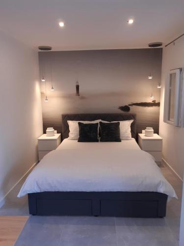 a bedroom with a large white bed with two night stands at Olive Grove House Lumbarda in Lumbarda