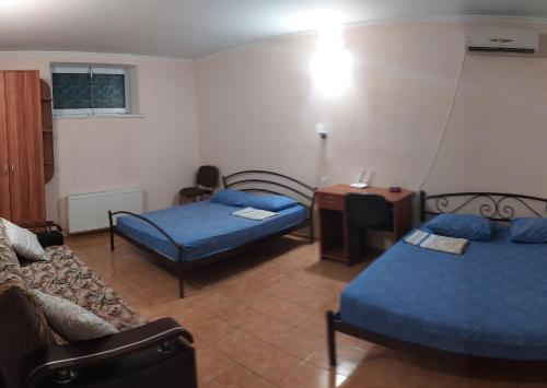 ein Wohnzimmer mit 2 Betten und einem Sofa in der Unterkunft Дом на Одесской ул. in Tschornomorsk