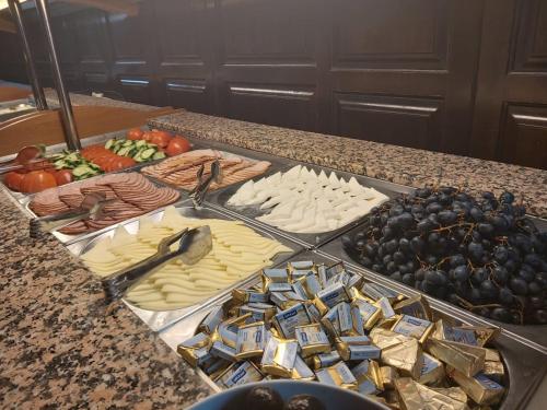 a buffet of cheese and fruit on a counter at Hotel Dobru in Slănic-Moldova