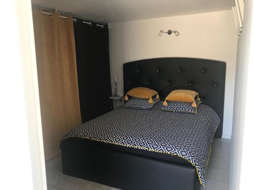 - un lit noir avec 2 oreillers dans l'établissement La perle rare, au Grau-dʼAgde