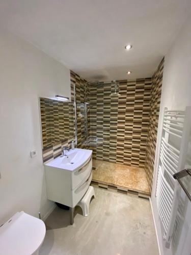 une salle de bain avec un lavabo blanc et des toilettes dans l'établissement Parenthèse au bord de l’étang, à Bages