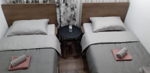 two beds sitting next to each other in a room at Apartments Jack in Bihać