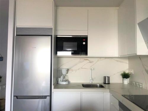 a white kitchen with a sink and a refrigerator at Marina Habanera in Almuñécar