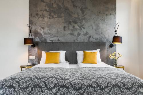 a bedroom with a large bed with two yellow pillows at Panorama Przemyśl in Przemyśl
