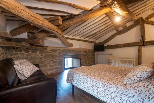 een slaapkamer met een bed in een kamer met houten plafonds bij Palacio de Sansol in Sansol