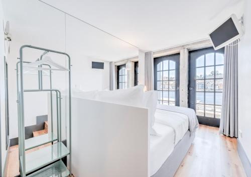 a white bedroom with a large bed and windows at Oporto Street Fonte Taurina - Riverfront Suites in Porto