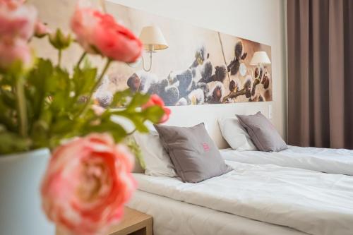 a hotel room with a bed and a couch and flowers at Cicha Zdrój in Solec-Zdrój