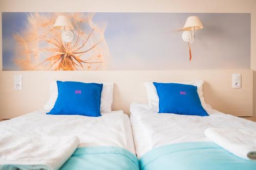 two beds in a room with blue pillows at Cicha Zdrój in Solec-Zdrój