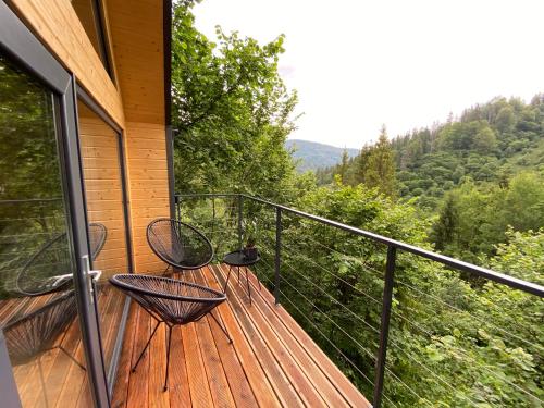 a balcony with two chairs and a view of the mountains at Villa Alpiyka in Slavske