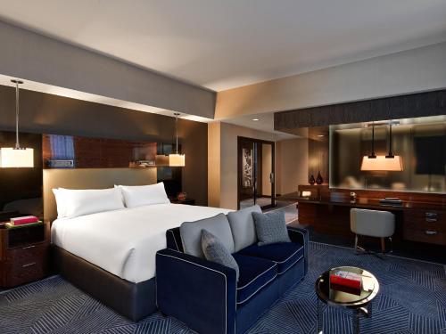 達拉斯的住宿－焦耳酒店，一间卧室配有一张大床和一张蓝色椅子