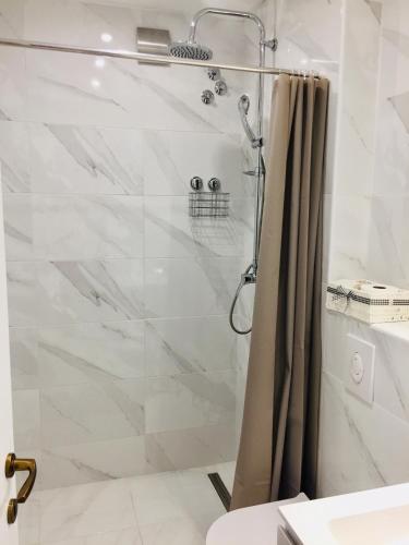 a shower with a glass door in a bathroom at Apartments Juraković in Živogošće
