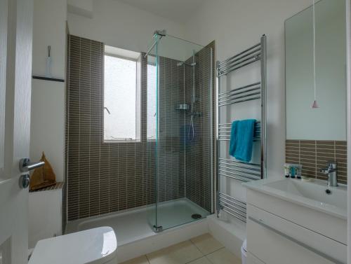 bagno con doccia in vetro e lavandino di Serene in Ryde a Ryde