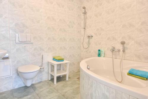 łazienka z wanną, toaletą i umywalką w obiekcie Villa Grenzschlösschen 01 w mieście Ahlbeck