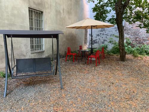 een tafel en stoelen met een parasol naast een gebouw bij La Meridiana in Piacenza