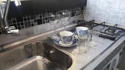 um balcão de cozinha com um lavatório e copos de vinho em Apartamento com Hidro em Belo Horizonte