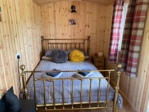 En eller flere senge i et værelse på Wee Highland Hideaway Hut