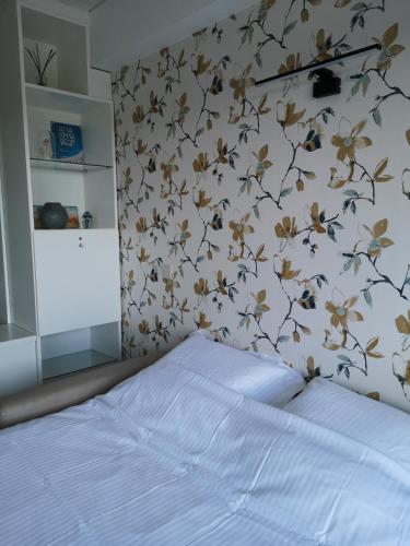 a bedroom with a bed with a floral wall at Zeester en koffie. in Oostduinkerke-Bad