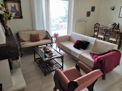 sala de estar con sofá, sillas y mesa en Panorama View Apartment 1 en Áyioi Apóstoloi