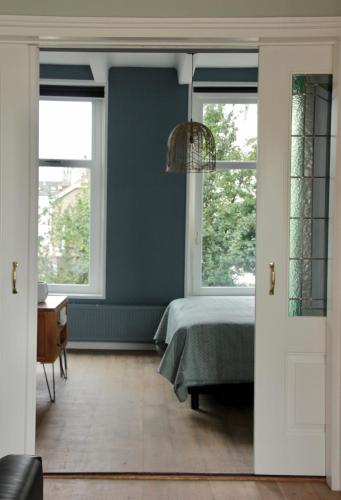 a bedroom with a bed and two windows at Bij Isa & Max in Kampen