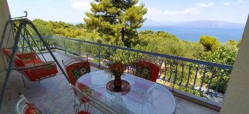 een balkon met een tafel en uitzicht op de oceaan bij Panorama View Apartment 1 in Áyioi Apóstoloi